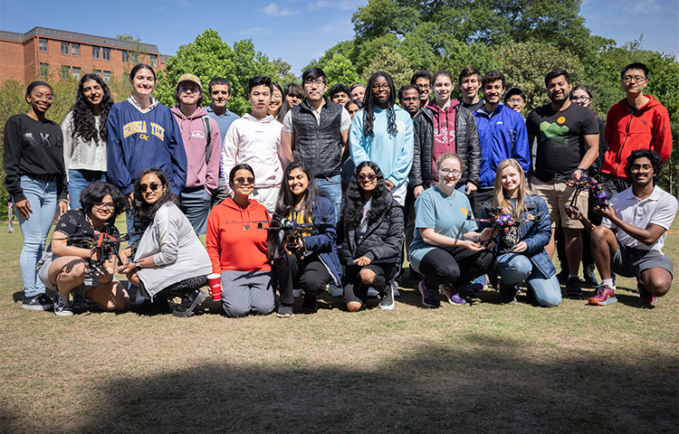 A group of students sitting outside with their drones