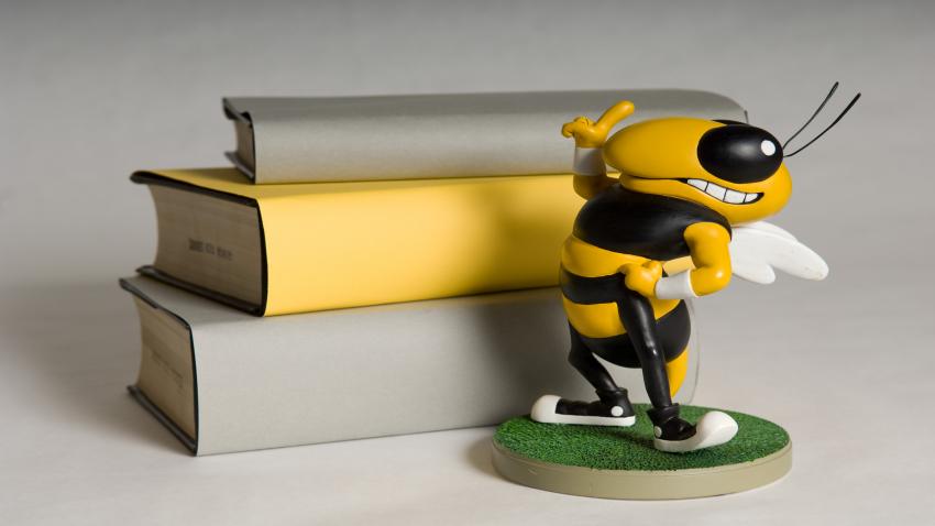 stack of books and buzz statue