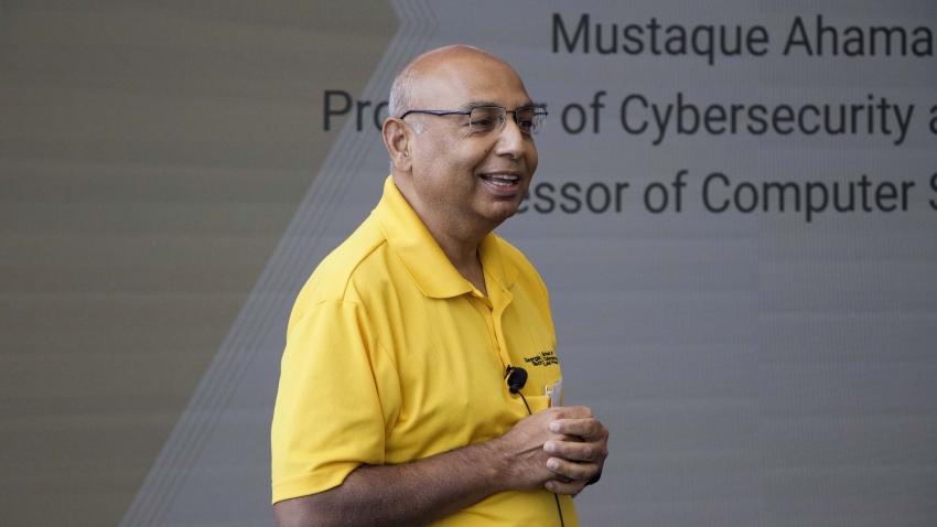 Man wearing a yellow shirt talking