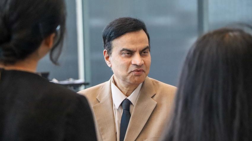 Man in brown suit wearing dark tie