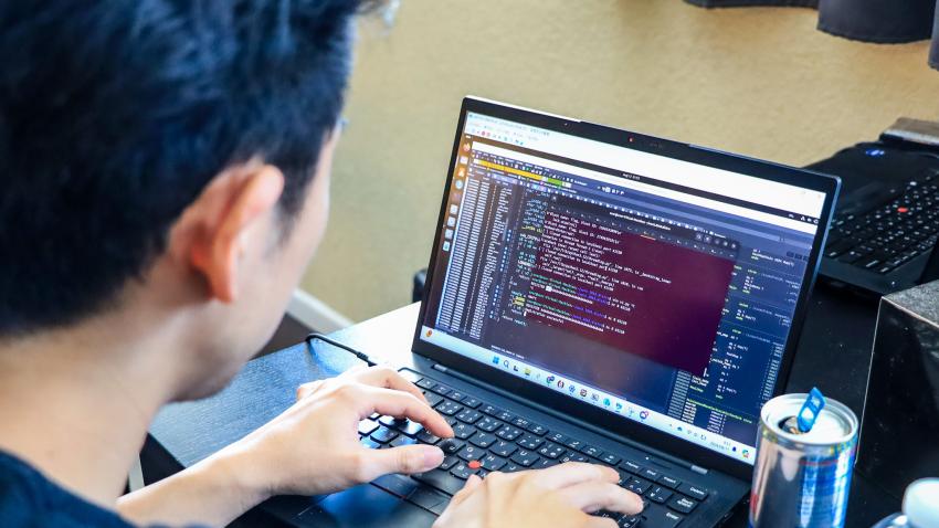 A man seated at a computer participating in the DefCon capture the flag competition