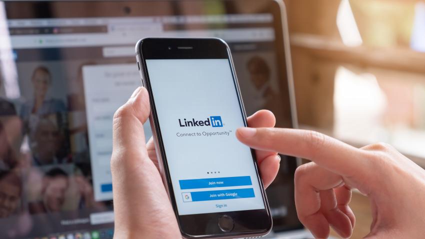 person touching the linkedin app on their phone