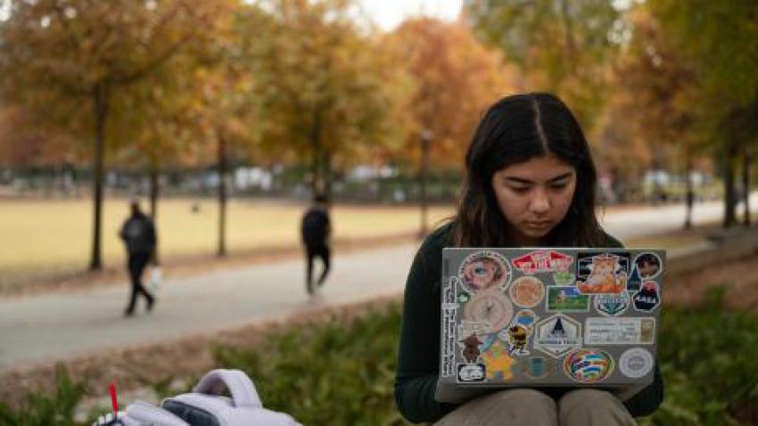 person on a laptop sitting outside