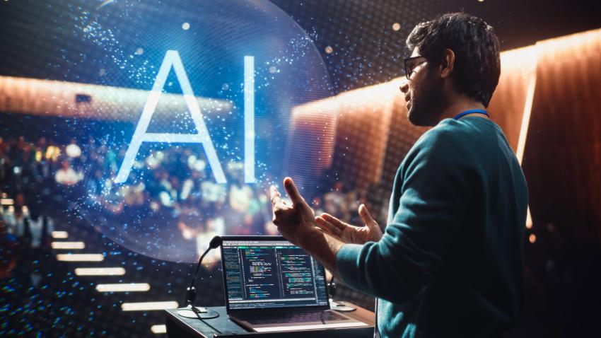 A man teaching in a lecture hall with AI hovering in front of him