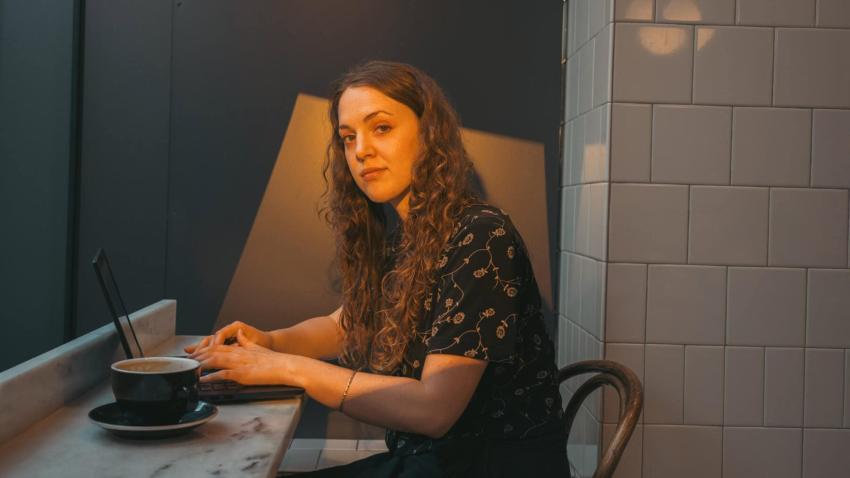 A woman sitting in a cafe working on a laptop