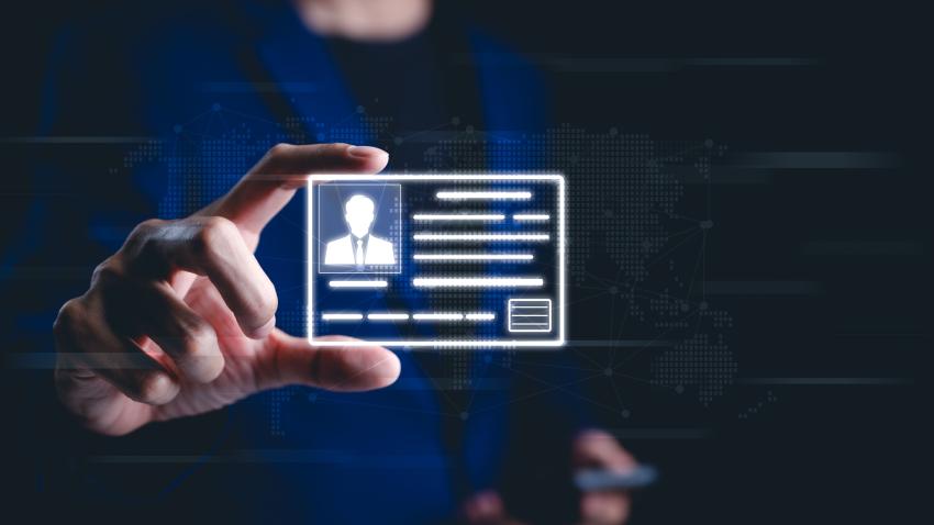 A person holding up a digital id. The id has the silhouette of a person wearing a suit and tie. 