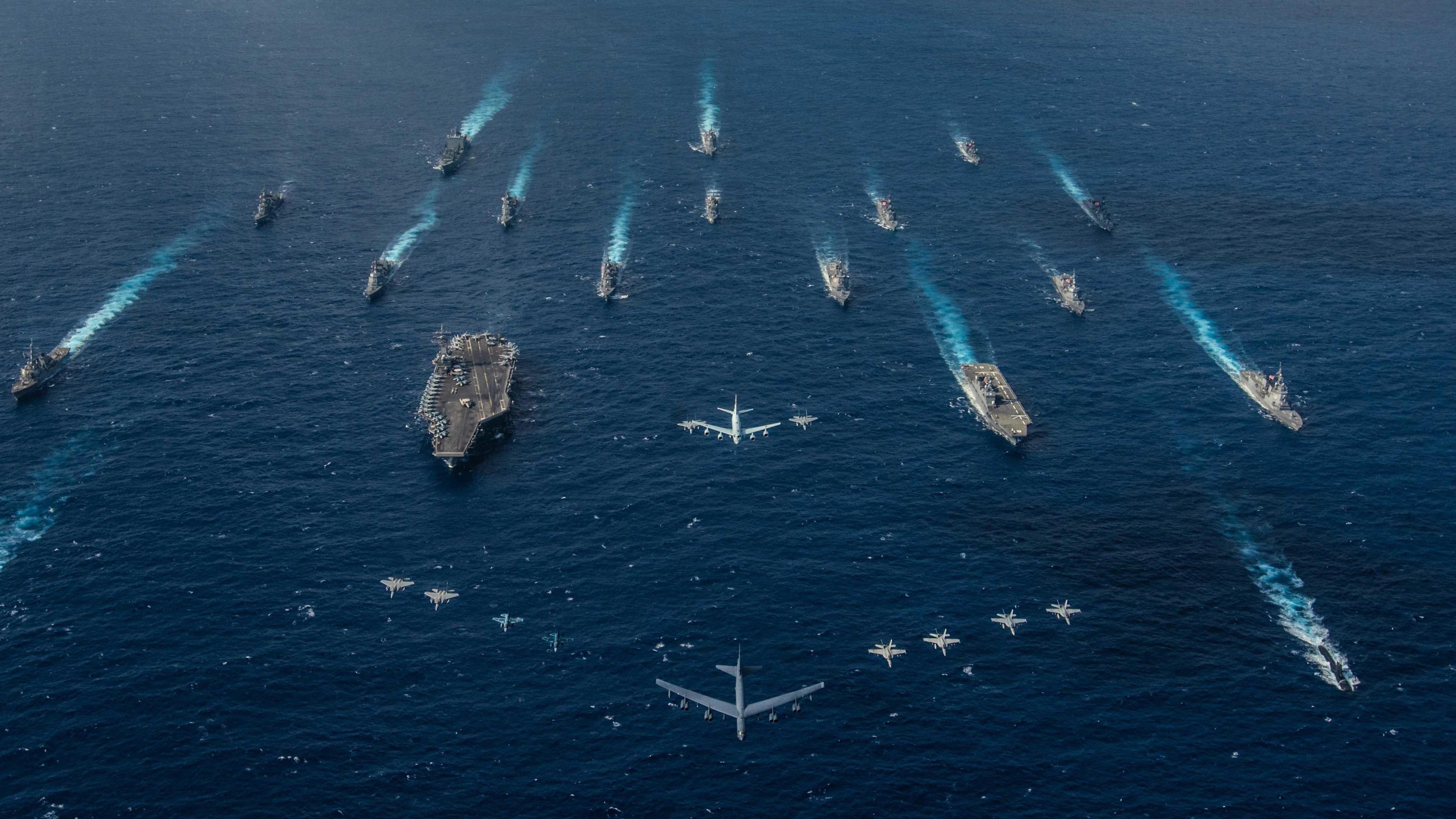 A fleet of naval vessels in the open sea.