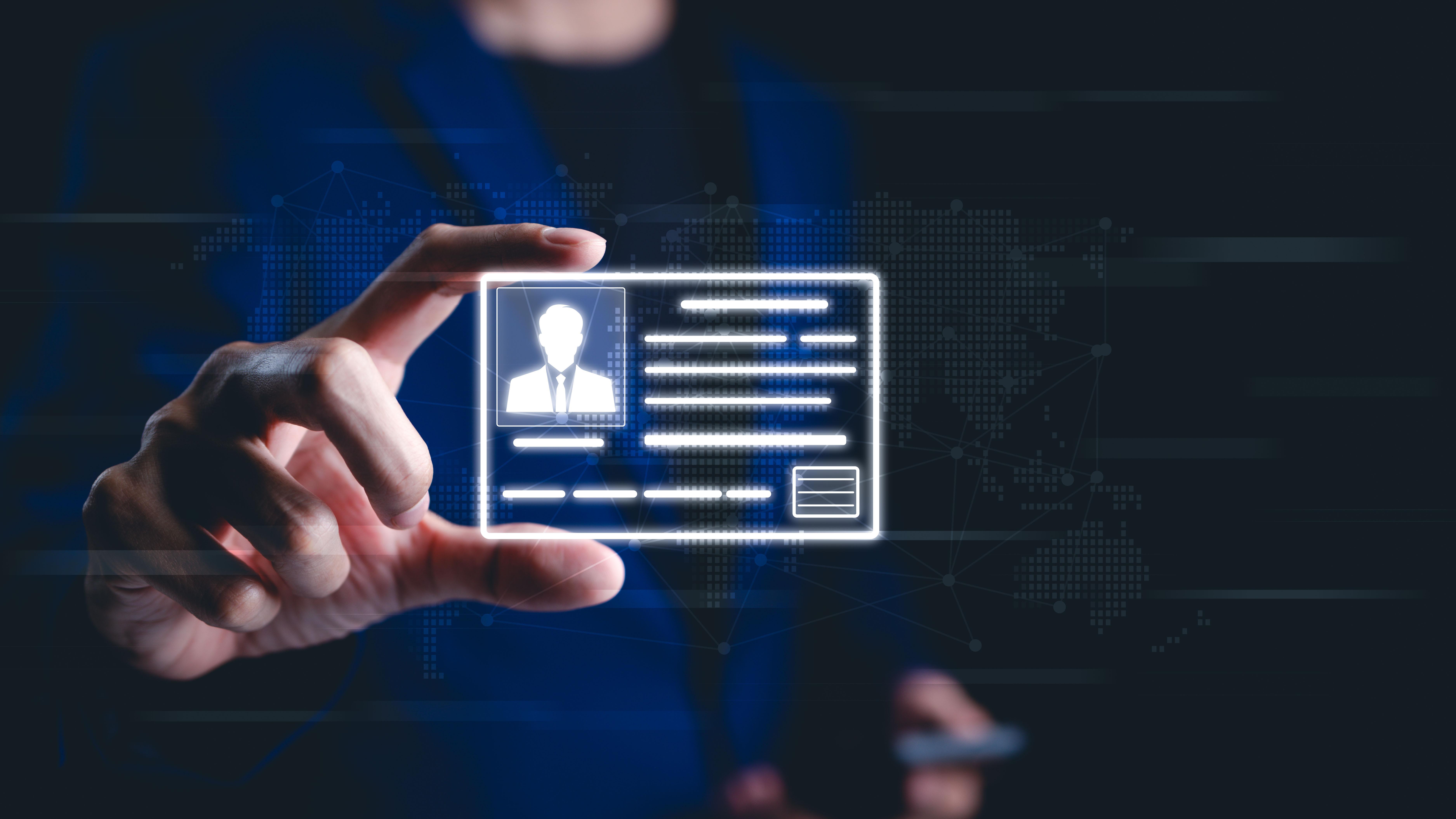 A person holding up a digital id. The id has the silhouette of a person wearing a suit and tie. 